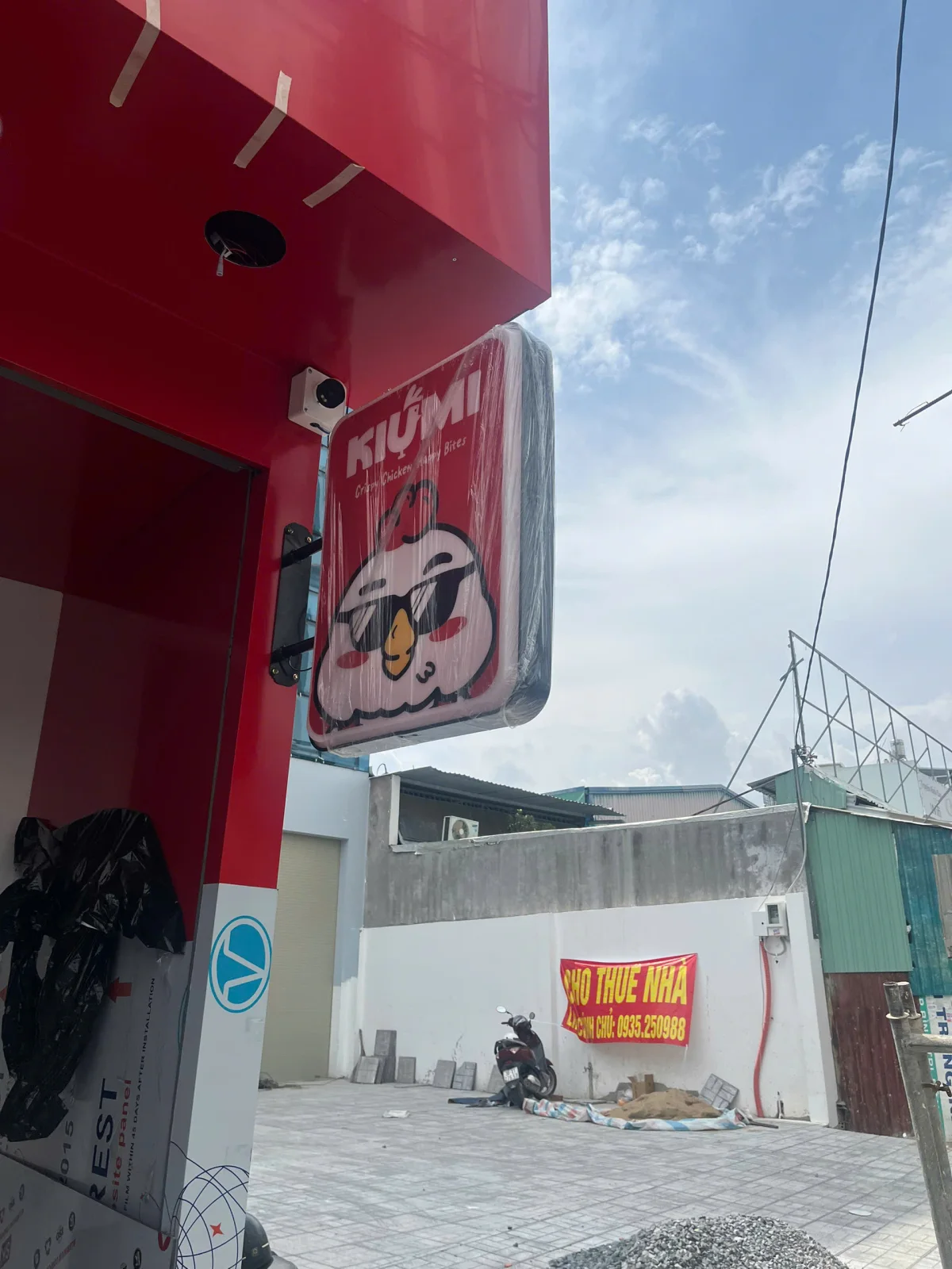 Biển vẫy KIUMI hình vuông đang được lắp đặt tại mặt tiền cửa hàng